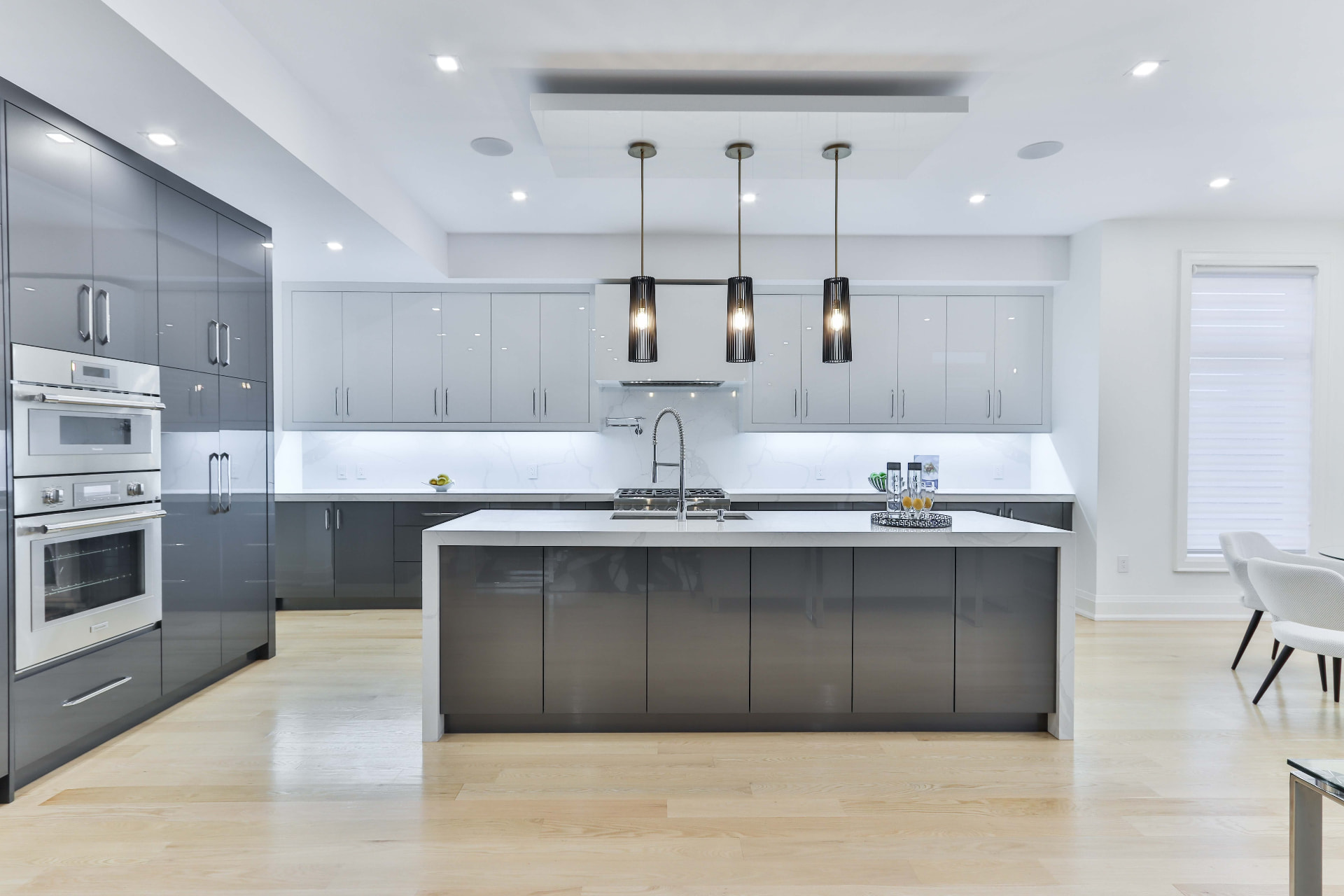 Gloss grey kitchen with marble backsplash and long island